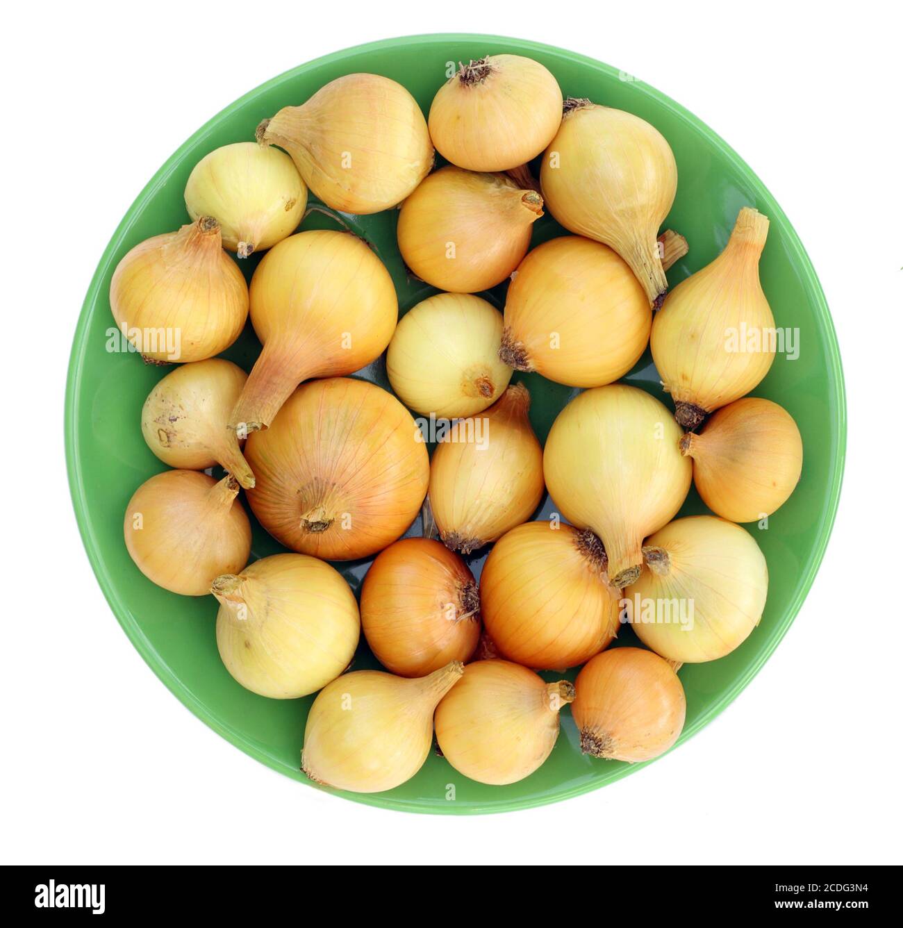 Gelbe Zwiebeln auf einem grünen Teller Stockfoto