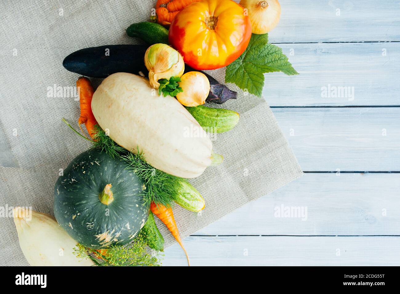 Frisches Gemüse auf dem Bauernhof: Zucchini, Karotten, Auberginen, Gurken, Tomaten, Zwiebeln, Kürbis, Dill und Petersilie auf einem Holztisch, Ansicht von oben, Gemüse legen Stockfoto