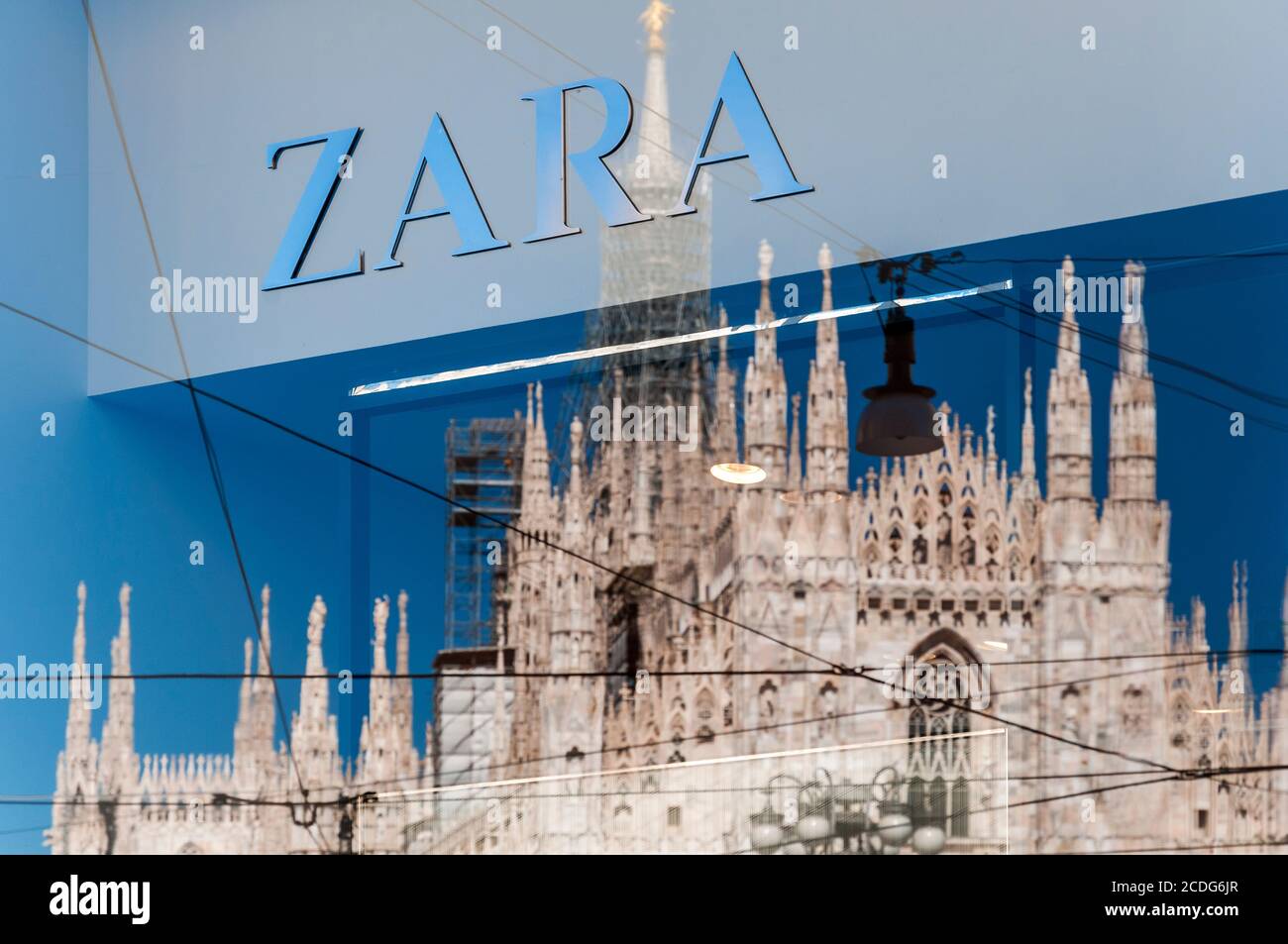 Das Logo des Bekleidungshändlers Zara mit der Kathedrale Duomo spiegelt sich im Schaufenstergeschäft in Mailand, Lombardei, Italien wider Stockfoto