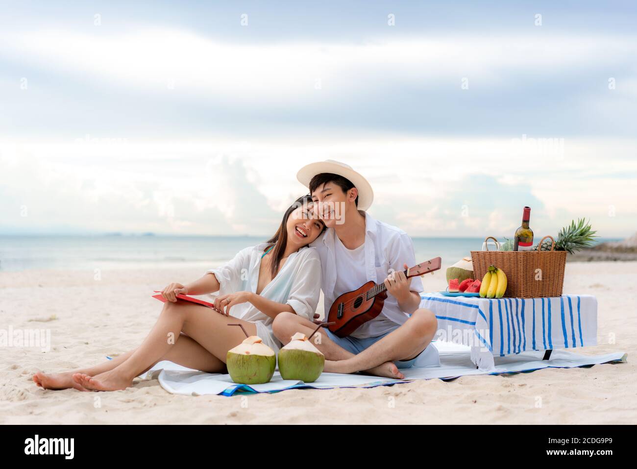 Asiatische Paar glücklich und genießen Sie die Reise Flitterwochen des Paares Liebhaber am Strand, indem Ukulele und singen gemeinsam Musik. Sommer, Urlaub, Stockfoto