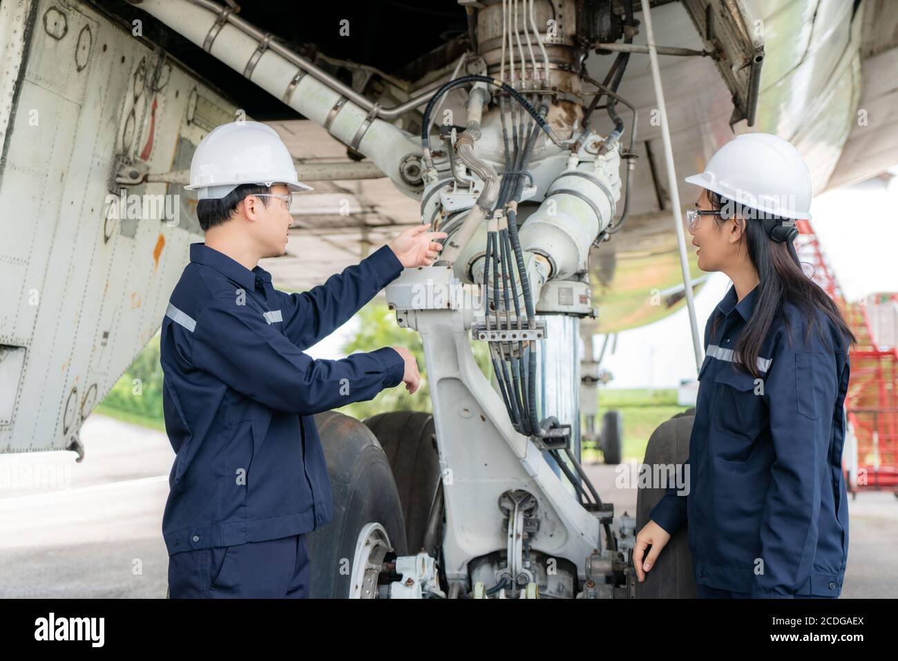 Asiatische Mann und Frau Ingenieur Wartung Flugzeug Team Reparaturen, Reparaturen, Modernisierung und Renovierung vor Flugzeug vom Flughafen. Stockfoto