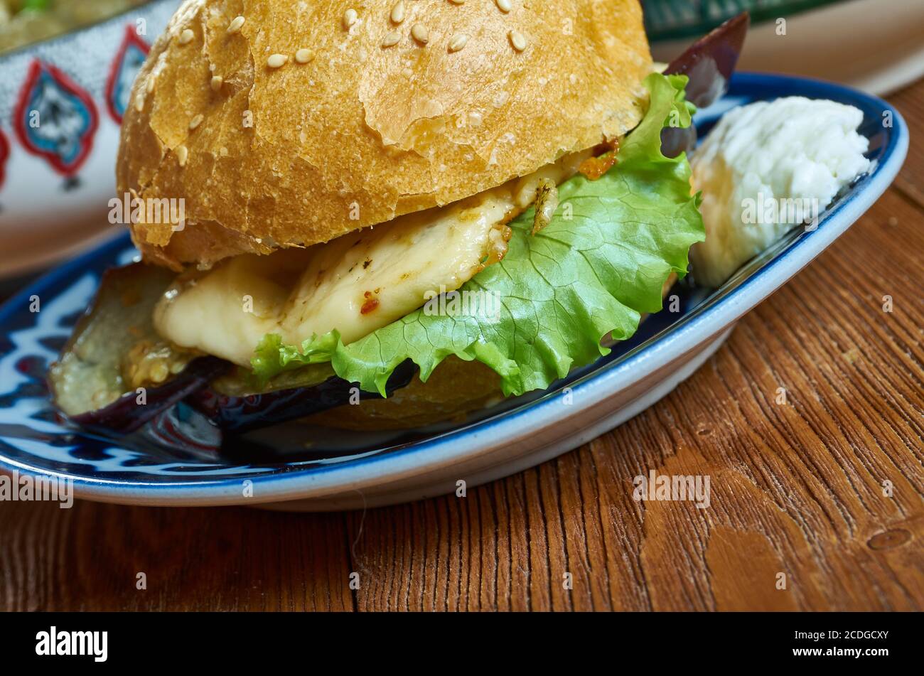 Halloumi Aubergine Burger, von Auberginen durch Frittieren in Semmelbröseln bis knusprig und golden, bevor sie in einem Burger-Brötchen mit gegrilltem Halloumi Füllung Stockfoto