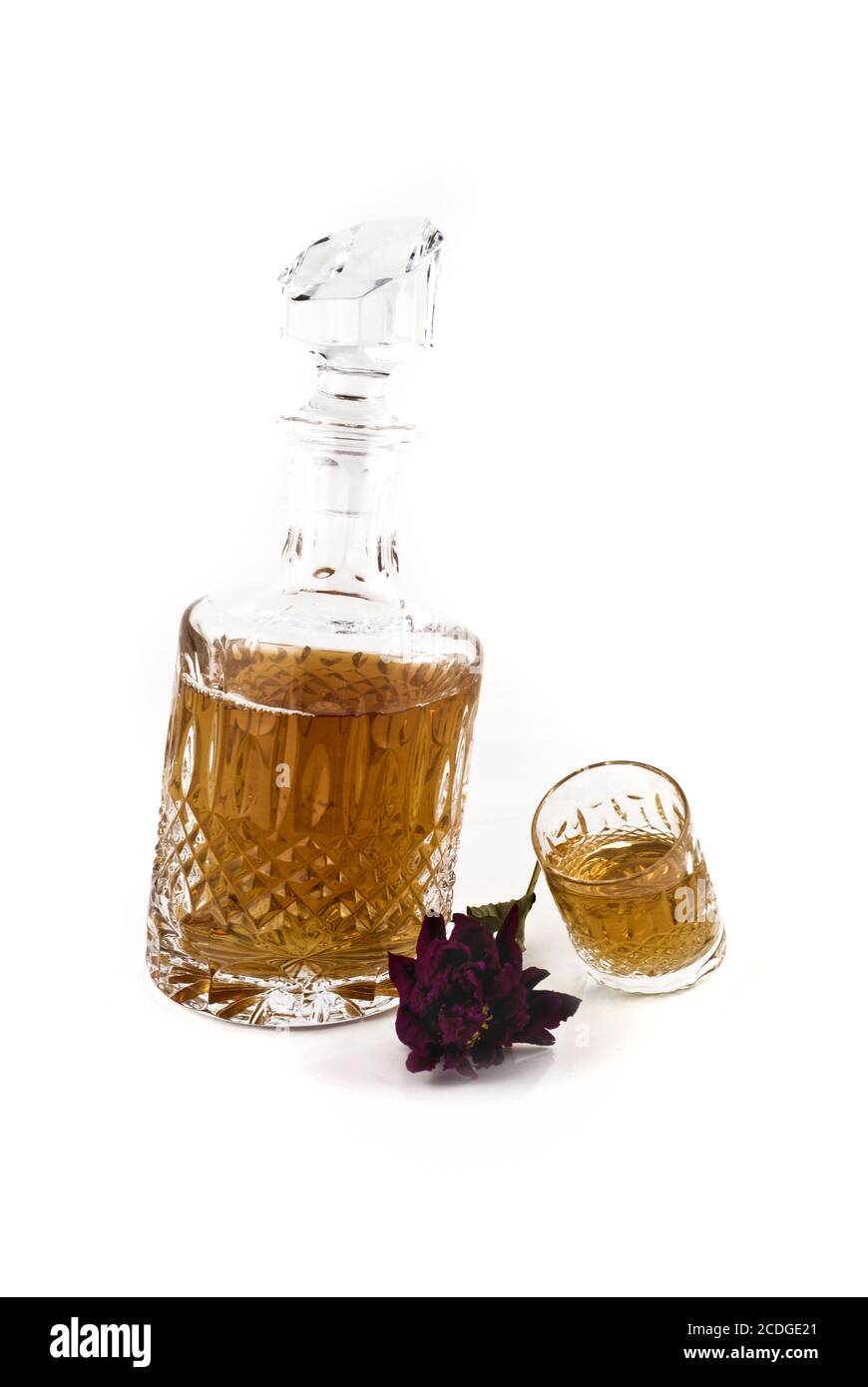 Kristalldekanter mit Jigger und Blume für alkoholische Getränke Stockfoto