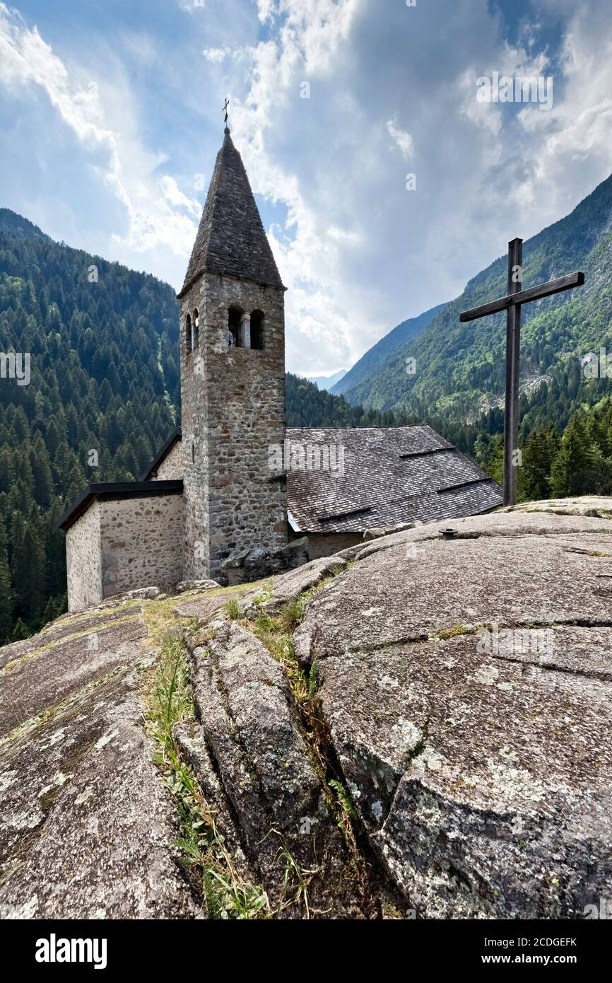 Die mittelalterliche Kirche Santo Stefano steht auf einem Felsvorsprung am Eingang des Genova-Tals. Carisolo, Trentino, Italien. Stockfoto