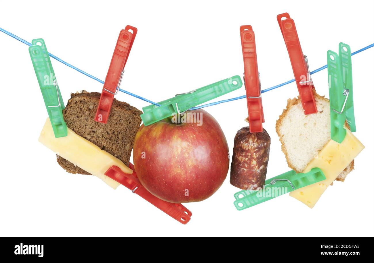 Käse, Brot, Wurst und Apfel hängen an einem Seil Stockfoto