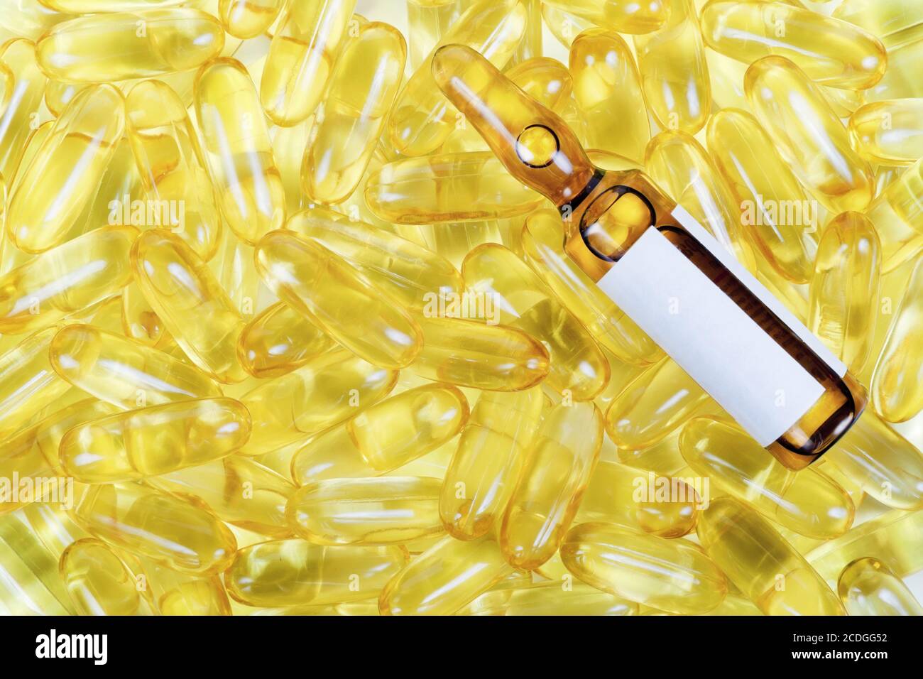 Goldene Pillen und gelbe Ampulle Stockfoto