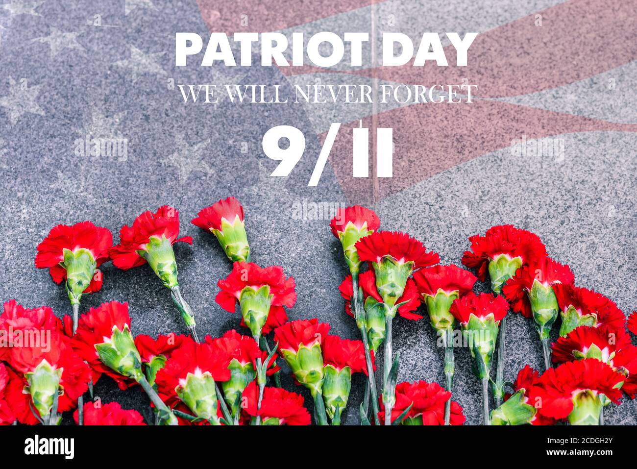 Nelken auf der Gedenkstätte mit der amerikanischen Flagge und der Phrase Patriots ' Day. September 11. Wir werden es nie vergessen. Jahrestag des Angriffs. Stockfoto