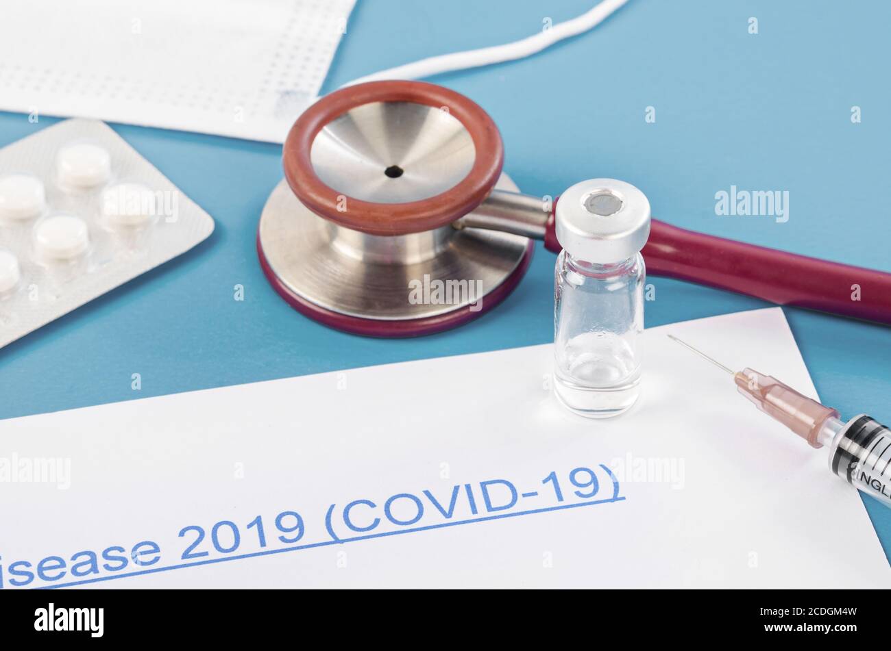 Coronavirus Disease 2019 mit Impfstoff und Pille auf blauem Hintergrund. Covid-19 Forschungskonzept. Stockfoto