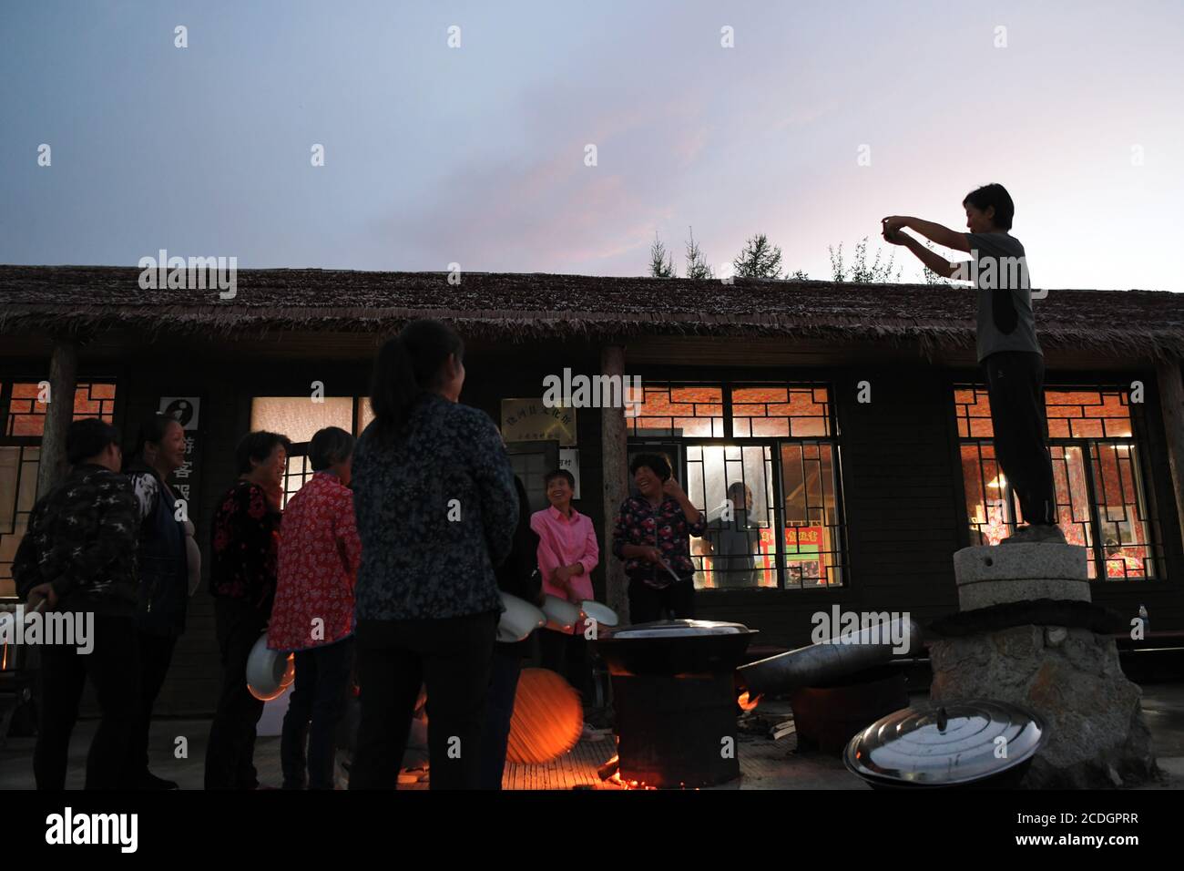 (200828) -- HARBIN, 28. August 2020 (Xinhua) -- Leng Juzhen (R) macht Fotos von Dorfbewohnern vor dem Tourismusdienstzentrum im Dorf Xiaonanhe im Bezirk Raohe, nordöstlich der Heilongjiang Provinz Chinas, 19. August 2020. In diesem Jahr ist Leng Juzhen das fünfte Jahr als Beamter, das Xiaonanhe zur Unterstützung der Armutsbekämpfung zugewiesen wurde. Durch die Bemühungen von Leng und anderen Dorfbeamten haben alle von Armut betroffenen Haushalte in Xiaonanhe 2018 die Armut abgeschütteln. In den letzten Jahren hat Leng die Dorfbewohner dazu beorderten, den ländlichen Tourismus und landwirtschaftliche Produkte wie Chilisauce, Käfig- Stockfoto