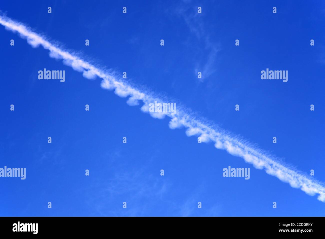 Weißer Flugzeugkontraingel, Kondensstreifen oder Dampfspur gegen blauen Himmel Stockfoto