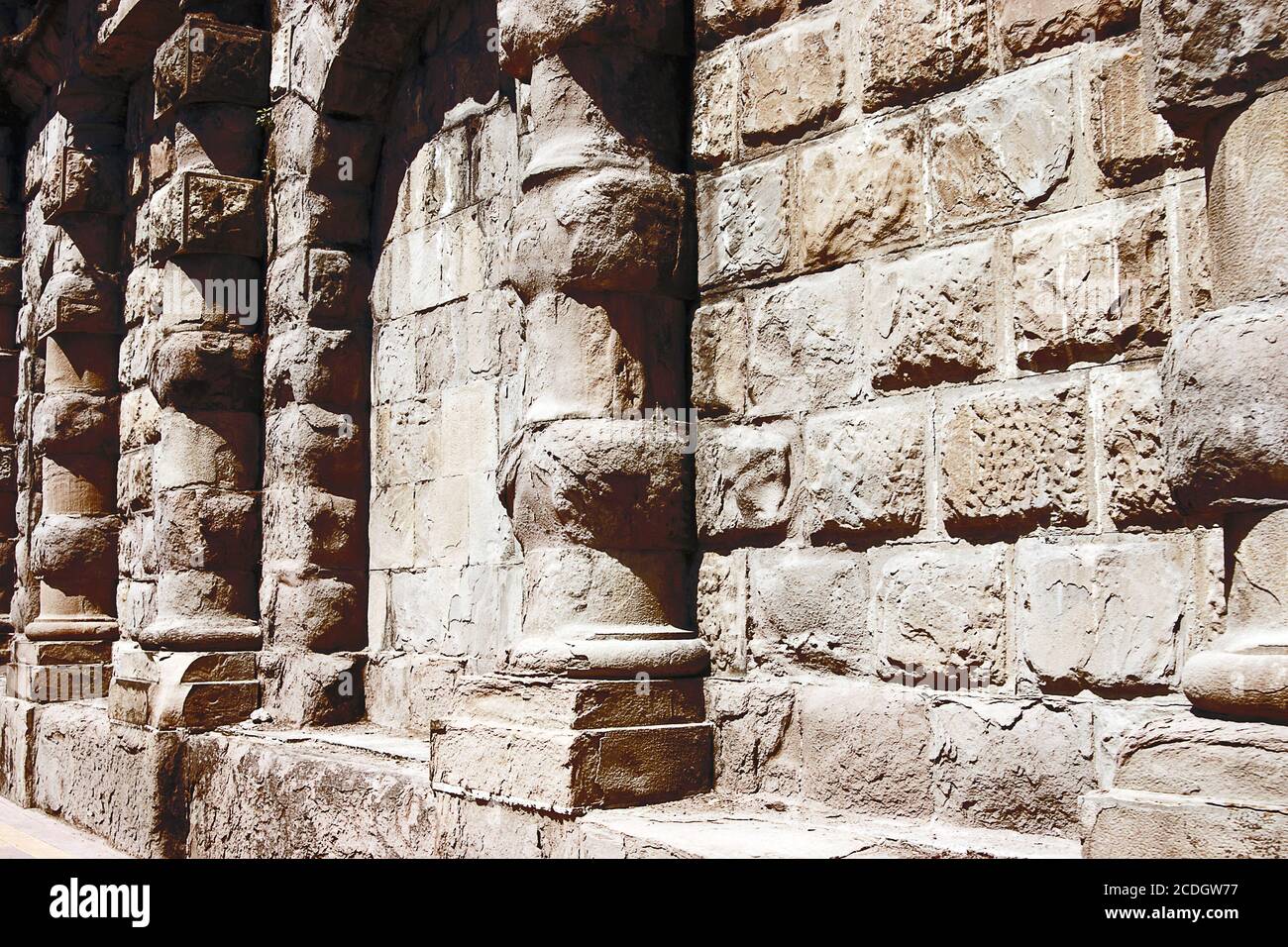 Steinmauer mit Säulen und einem Bogen in mittelalterlichen st Stockfoto