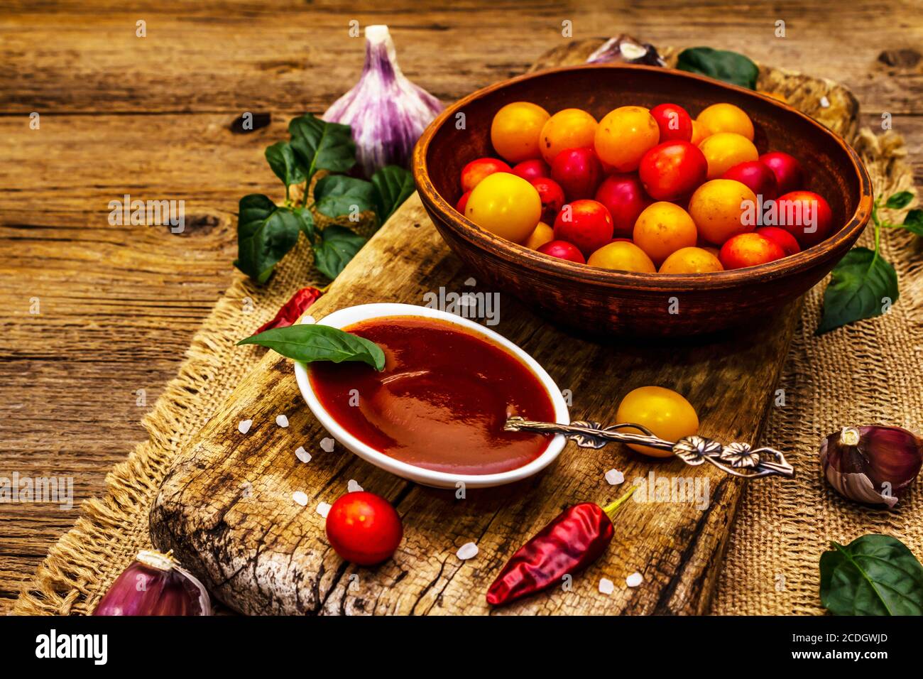 Tkemali georgianische Kirsche Pflaumensoße mit Knoblauch und Pfeffer. Traditionelles Dip aus reifen Früchten und Gewürzen. Vintage Holzhintergrund, kopieren Raum Stockfoto