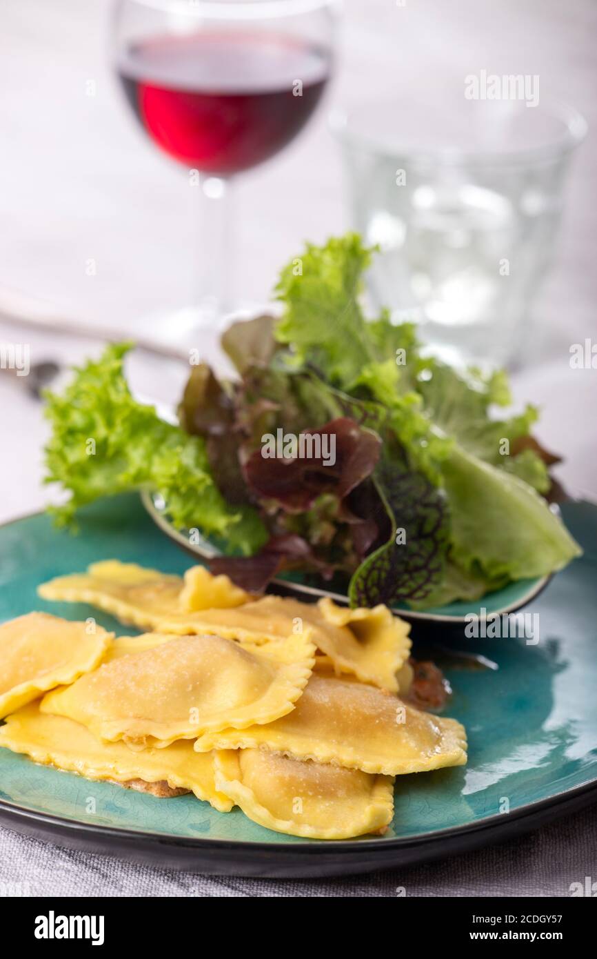 Ravioli mit Sahnesauce und Salat Stockfoto