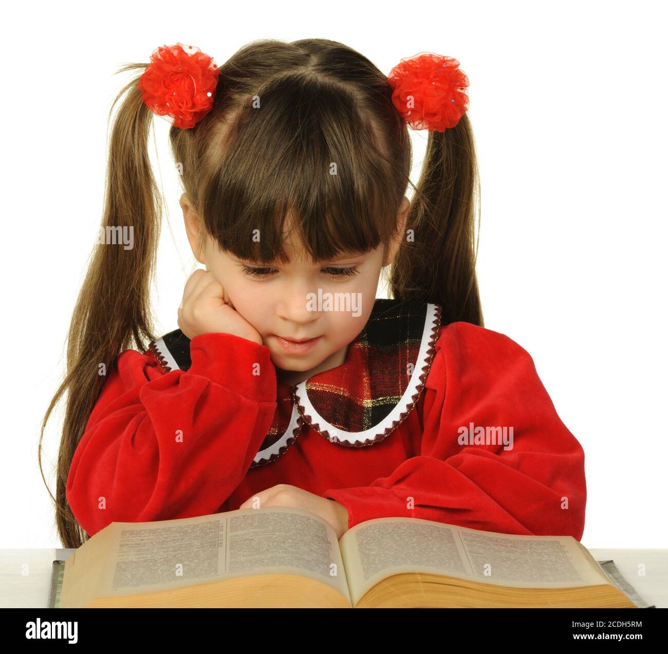 Das kleine Mädchen vor dem großen wissenschaftlichen Buch Stockfoto