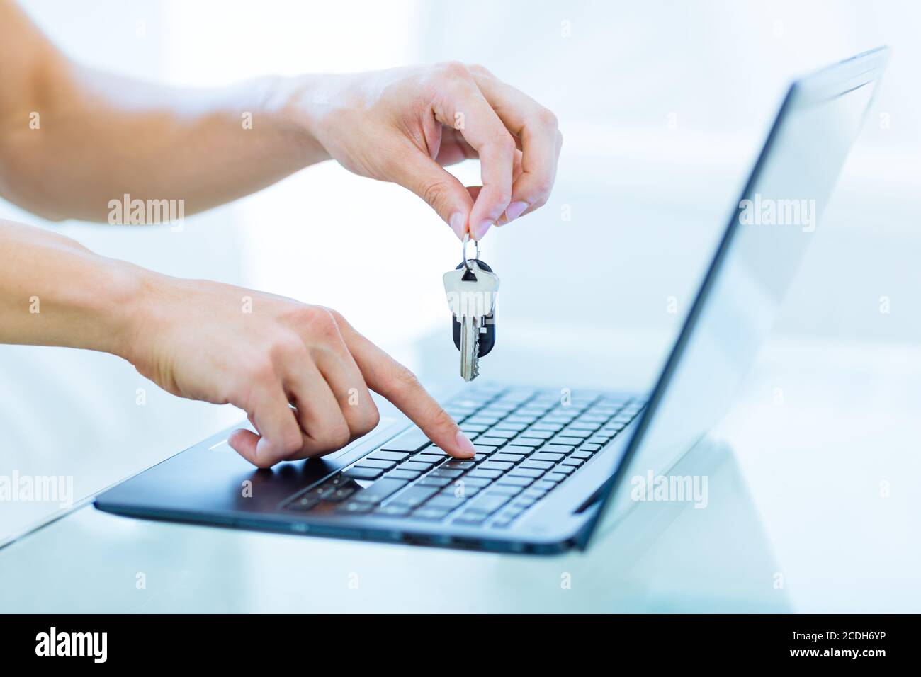 Nahaufnahme der Hände einer männlichen Person, die die Tasten beim Tippen auf einer Laptop-Tastatur hält. Online Buchung und Vermietung Konzept. Stockfoto