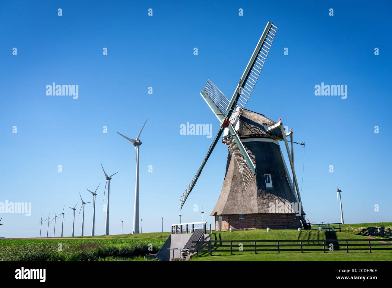 Alte Windmühle in Kombination mit neuen Windturbinen, die saubere Energie erzeugen Stockfoto