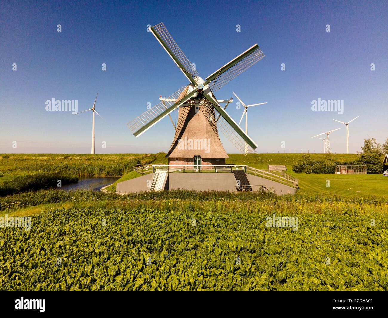 Alte Windmühle in Kombination mit neuen Windturbinen, die sauber erzeugen Energie Stockfoto