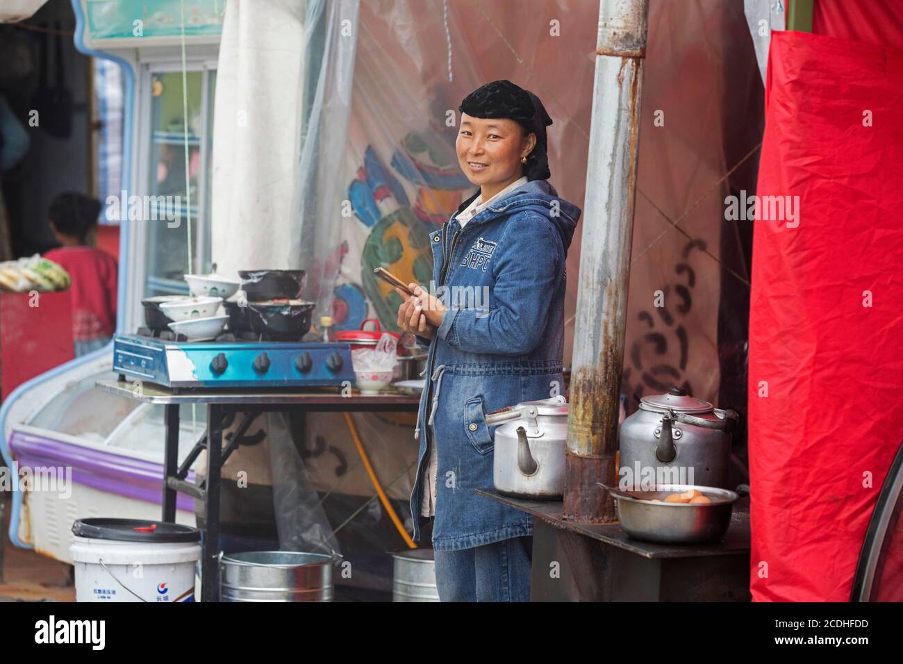 Tibeterin kocht Streetfood / Street Food in einem kleinen Dorf im Himalaya, China Stockfoto