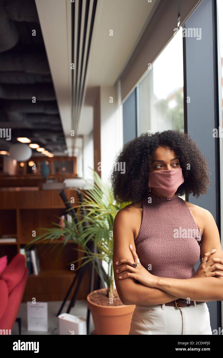 Afrikanische Geschäftsfrau trägt Gesichtsmaske im Büro Blick aus Angezeigt Stockfoto