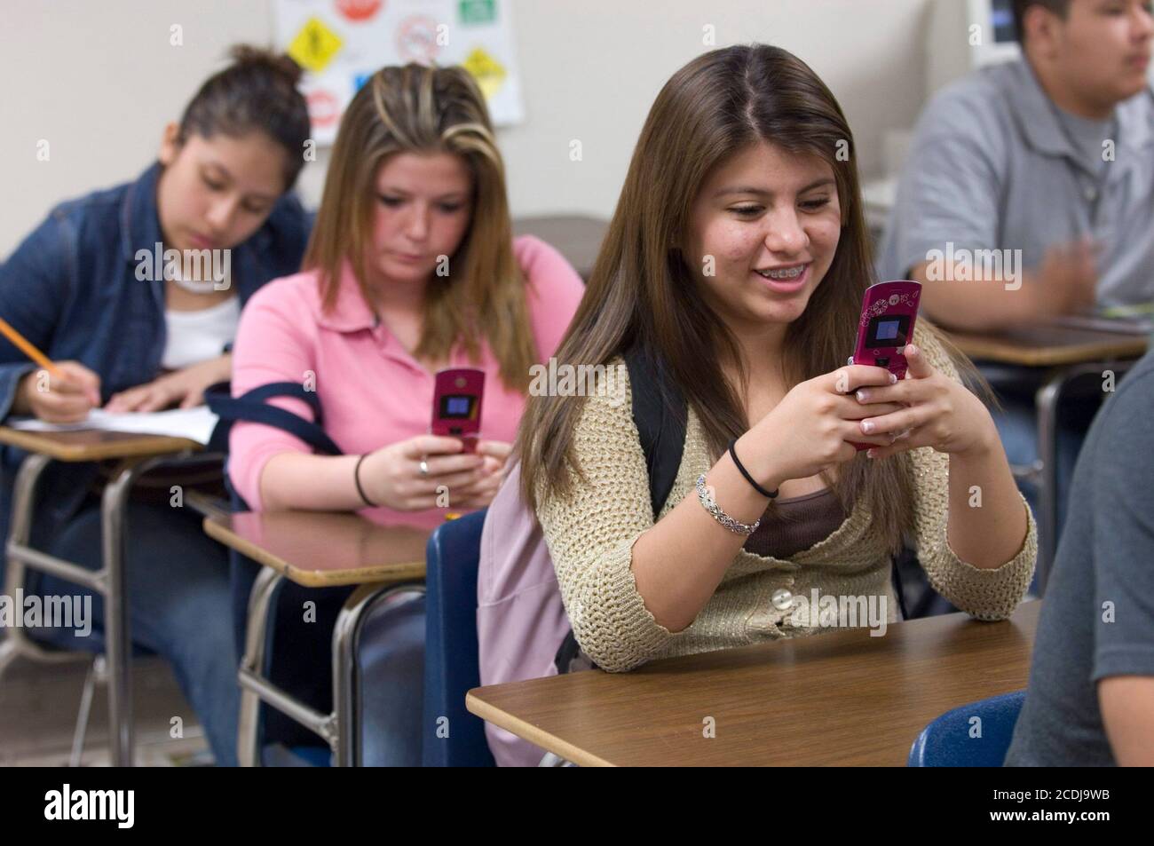 Austin, TX USA, 19. Mai 2007: Hispanische Schülerin der neunten Klasse (9. Klasse) SMS an eine Freundin, die hinter ihr mit einem Mobiltelefon im Mathematikunterricht in Akins High sitzt. ©Bob Daemmrich / Stockfoto