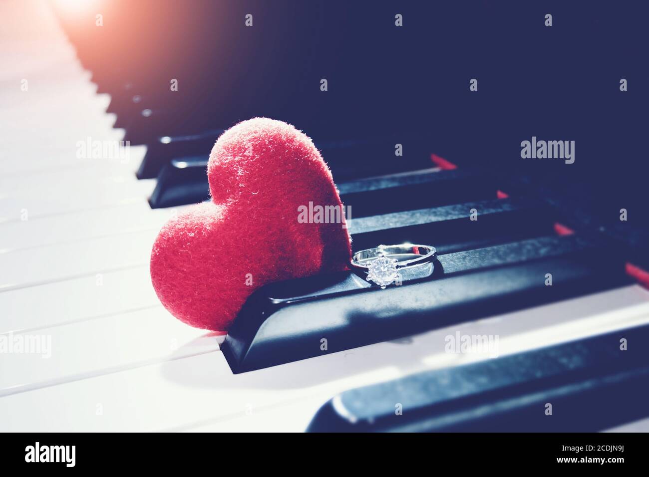 Ring und ein Herz auf Klavier, vintage Ton. Valentinstag Hintergrund, Hochzeitstag. Liebeskonzept Stockfoto