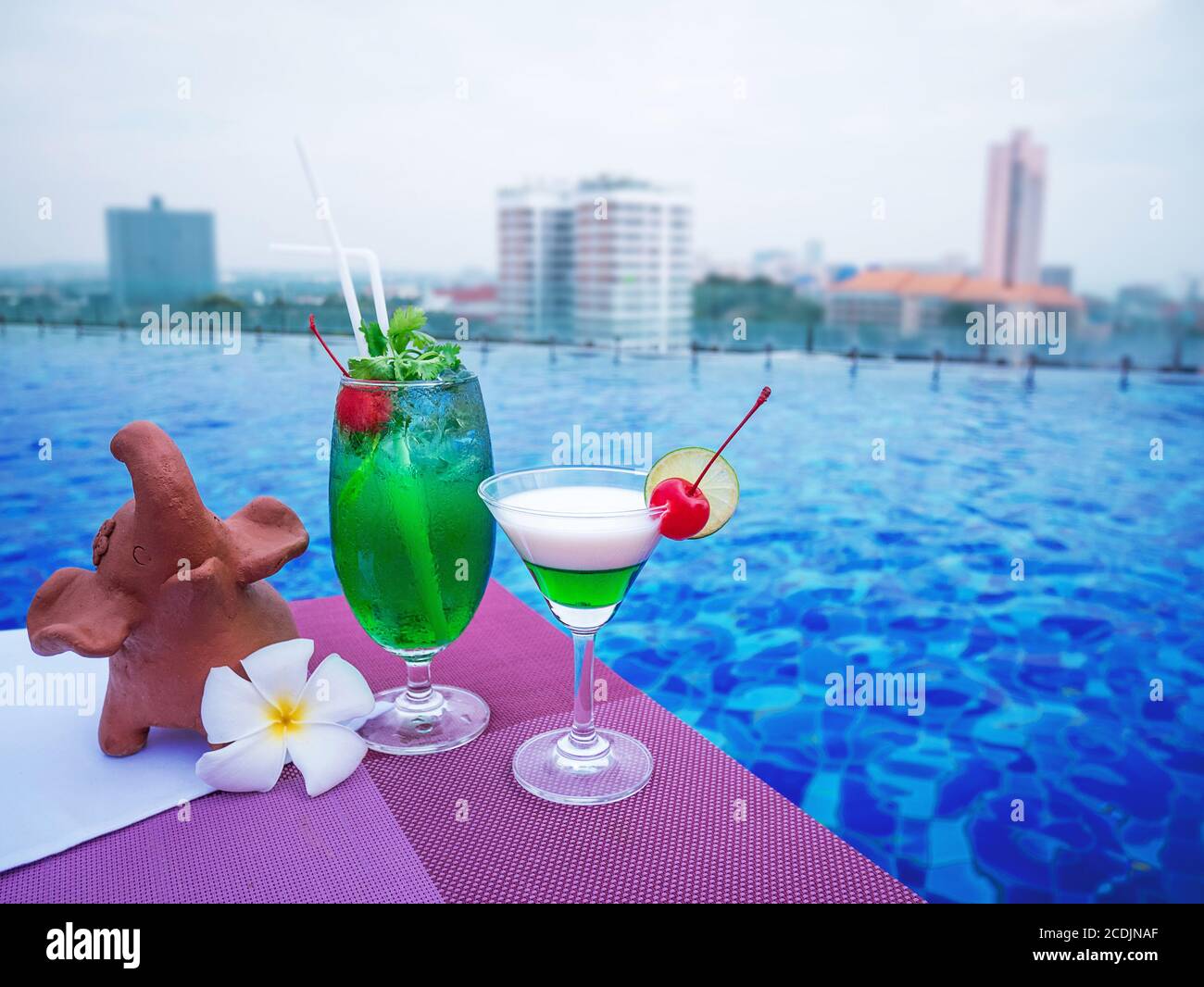 Cocktailgläser am Swimmingpool mit Blick auf die Stadt Stockfoto