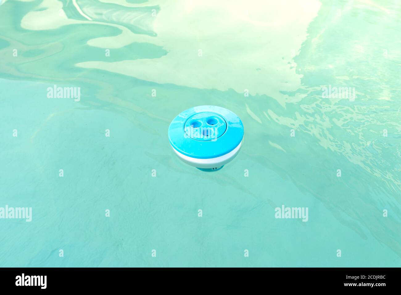 Blaue Chlorspender schwimmend in einem Pool zu Hause, Reinigung und Pflege des inländischen Pools. Stockfoto