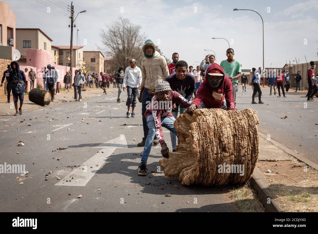 Johannesburg, Südafrika. August 2020. Menschen bereiten sich darauf vor, eine Straße während eines Protestes über den Tod eines Teenagers im Eldorado Park, Johannesburg, Südafrika, am 27. August 2020 zu verbarrikadieren. Der südafrikanische Präsident Cyril Ramaphosa hat am Freitag der Familie von Nathaniel Julius, einem 16-jährigen Jungen, der diese Woche von der Polizei getötet worden sein soll, sein Beileid ausgesprochen. Es wird behauptet, dass Nathaniel Julius Anfang dieser Woche auf der Suche nach Nahrung das Haus verlassen und von der Polizei erschossen wurde. Quelle: Yeshiel/Xinhua/Alamy Live News Stockfoto