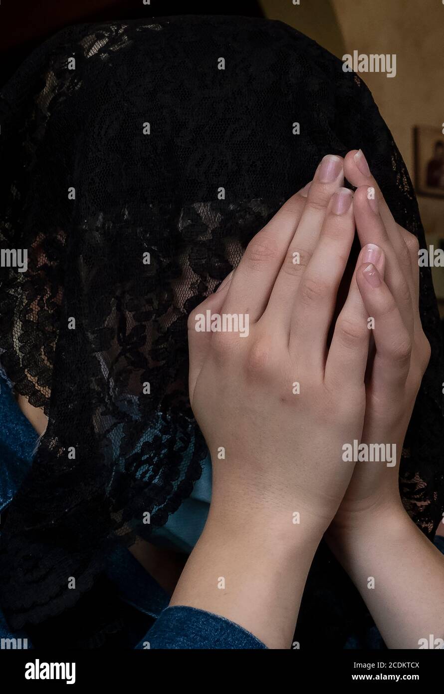 Frau mit schwarzem Schleier im Gebet Stockfoto