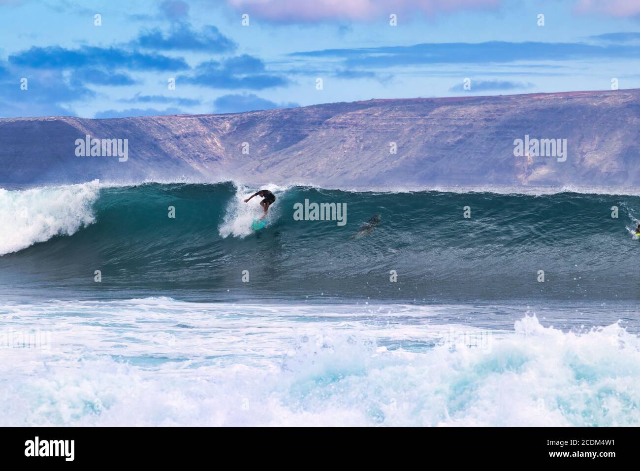 Eineige High-Energy-Silhouetten-Surfer, die auf Maui eine große Welle reiten. Stockfoto