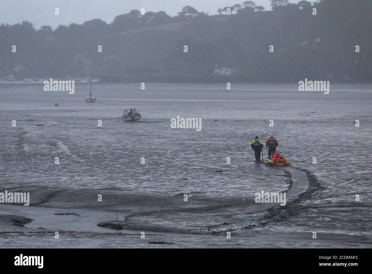 Rettung des Mietbootes auf Grund in Restonguet Creek, Cornwall. Die Flut wird sie nicht vor 3 UHR MORGENS abtreiben und schlechtes Wetter wird erwartet. Stockfoto