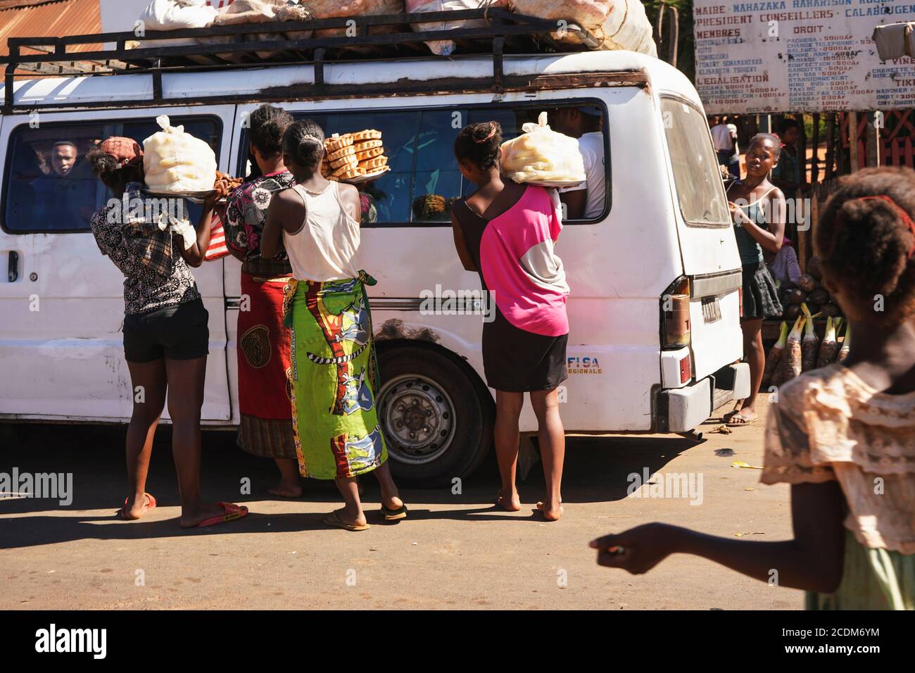 Toliara, Madagaskar - 05. Mai 2019: Gruppe unbekannter madagassischer Frauen, die Lebensmittel an Fahrgäste im weißen Bus verkaufen. Es gibt nicht viele Geschäfte, Waren sind üblich Stockfoto