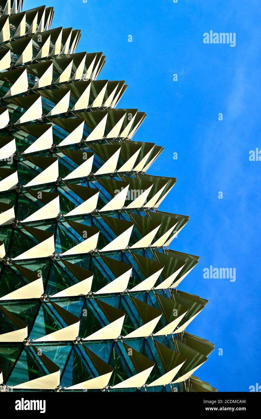 Nahaufnahme eines Bogens aus Dreieck und Pyramide Formen auf einer reflektierenden Glasoberfläche gegen einen blauen Himmel Hintergrund Stockfoto