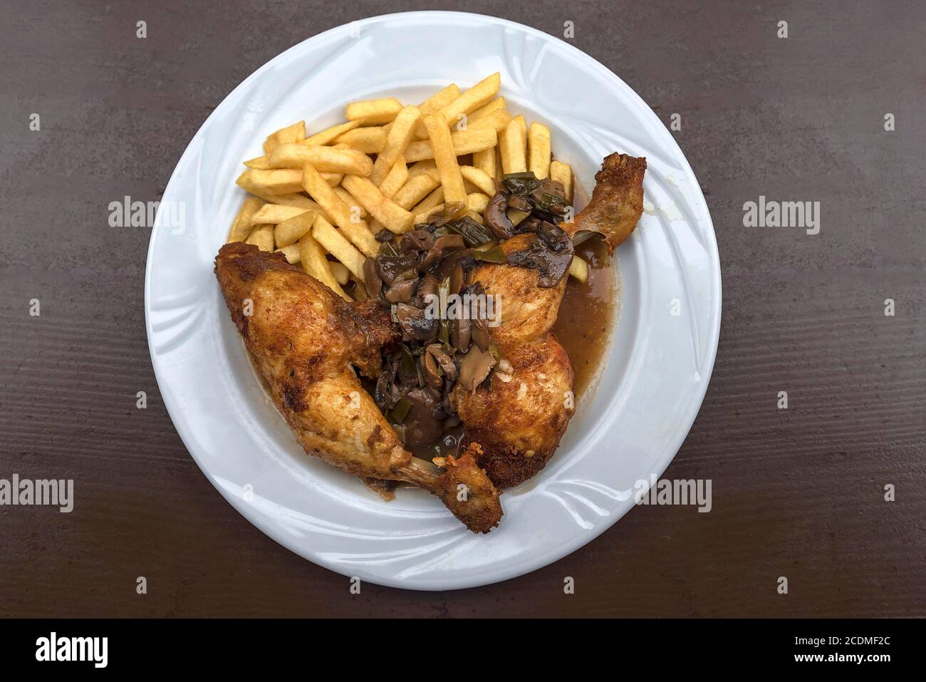 Zwei Hähnchenschenkel mit PilzFrühlingszwiebeln, Pommes frites, serviert auf Teller, Unterfranken, Bayern, Deutschland Stockfoto