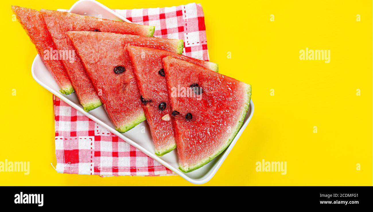 Stücke von Wassermelone in Schüssel auf Farbhintergrund, in Scheiben geschnittene Wassermelone, gesunde Früchte Stockfoto