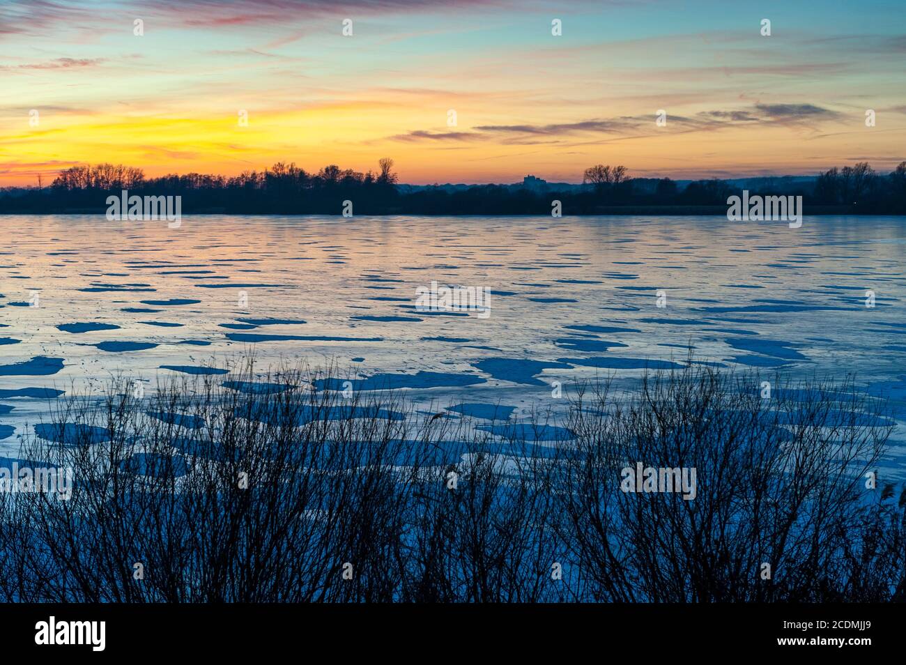 Winterabend am See, Eis auf dem gefrorenen Dolmen im Winter bei Sonnenuntergang, Lembruch, Niedersachsen, Deutschland Stockfoto