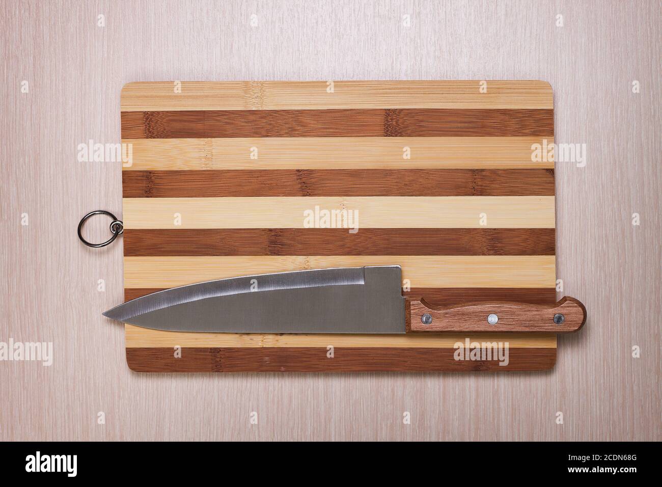 Großes Messer und Brotbrett auf dem Tisch Stockfoto