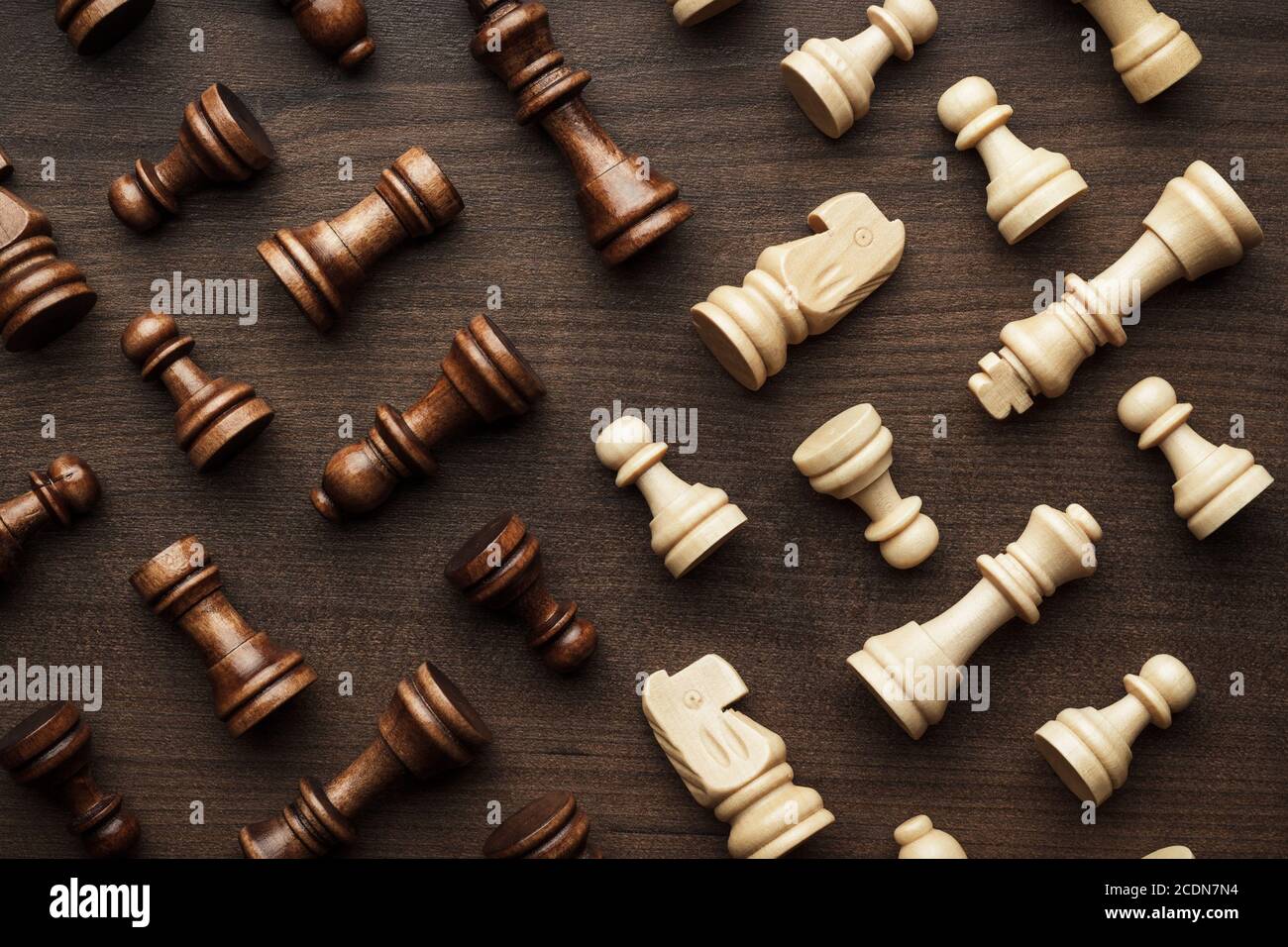Schachfiguren auf braunem Holztisch Hintergrund Stockfoto