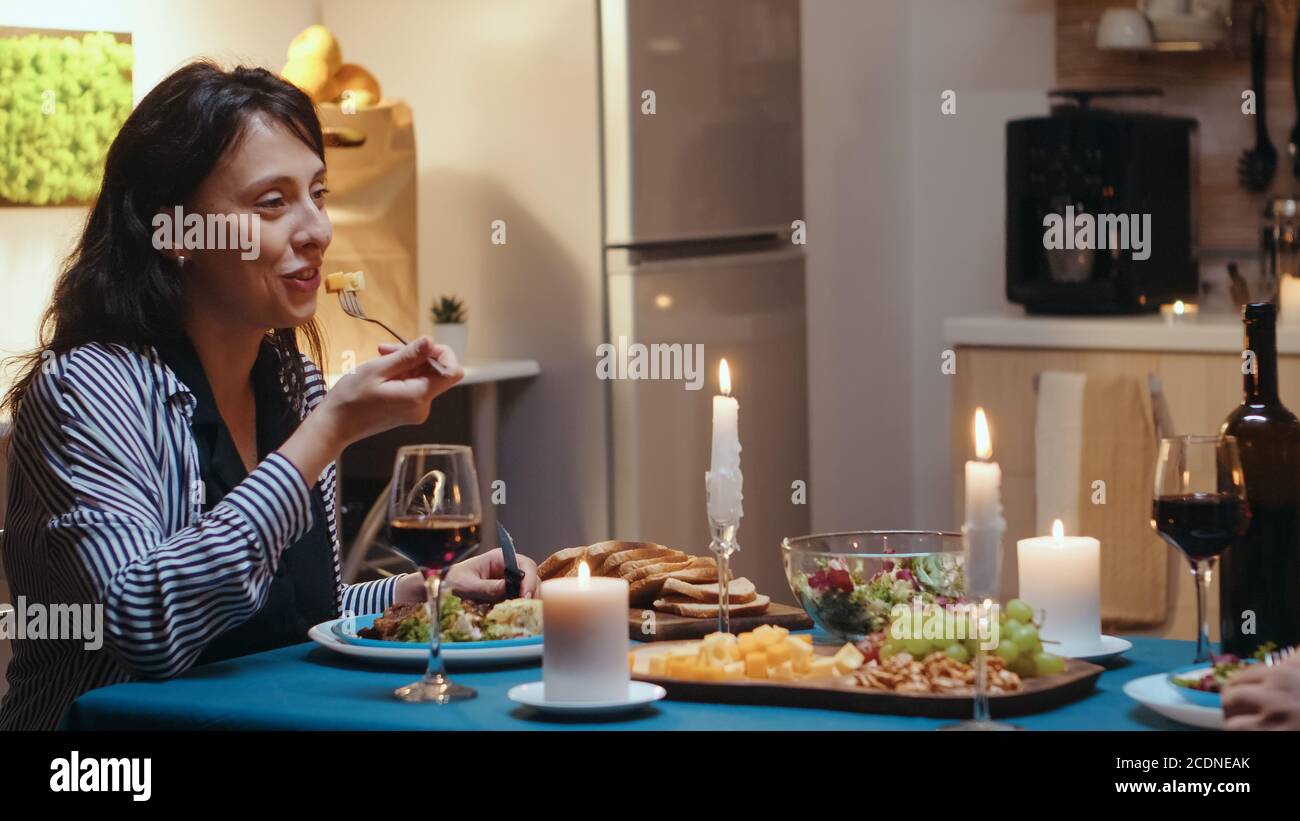 Pärchen essen und trinken Wein mit Frau im Vordergrund beim festlichen