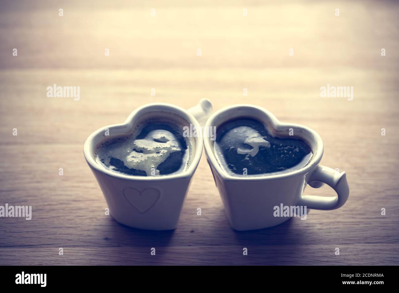 Schwarzer Kaffee, Espresso in zwei herzförmigen Tassen. Liebe, Valentine#39;s Tag, vintage Stockfoto