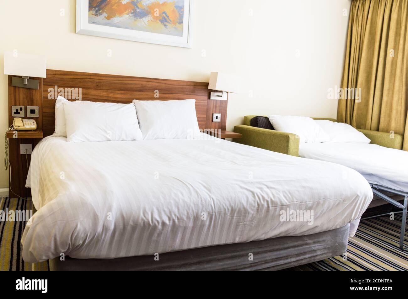Hotelzimmer mit Doppelbett und Schlafsofa Stockfoto