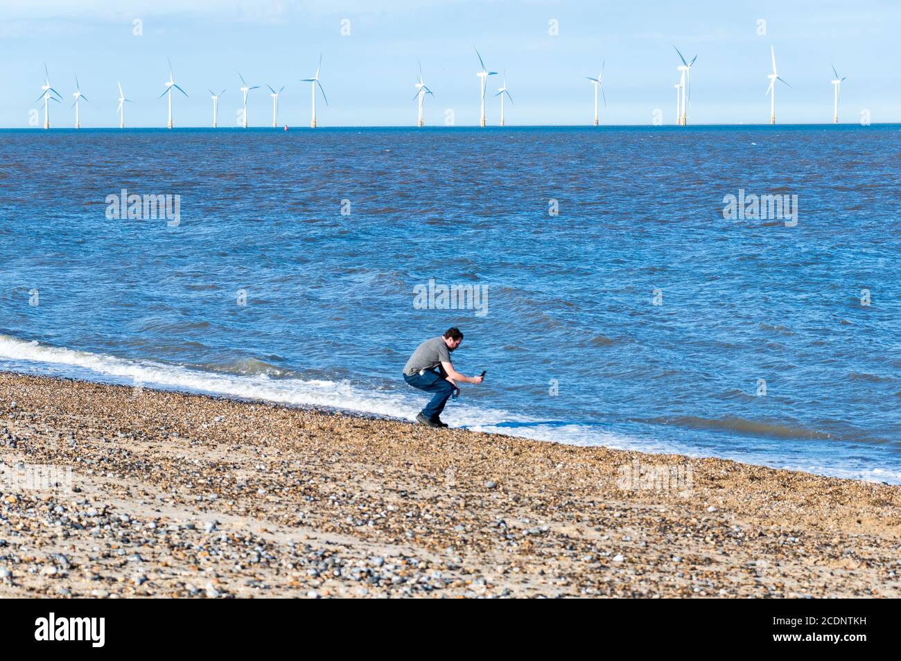 Mann, der mit einem Handy Wellen in Great Yarmouth, Norfolk, England fotografiert Stockfoto