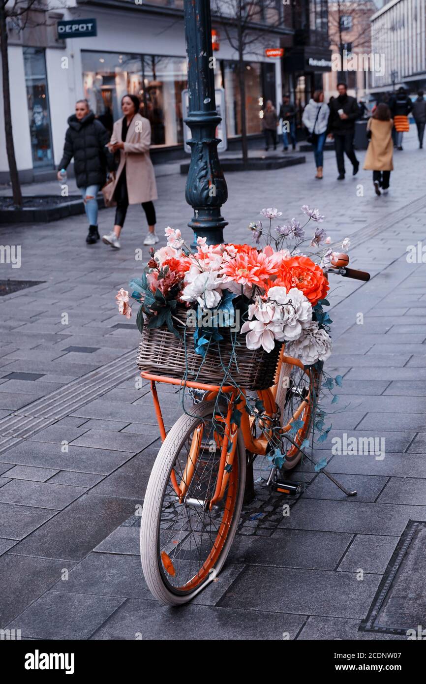 Fahrrad mit bunten Blumen in einer Einkaufsstraße in der Düsseldorfer Altstadt. Die Altstadt ist ein beliebtes Einkaufsviertel mit vielen Geschäften und Restaurants. Stockfoto