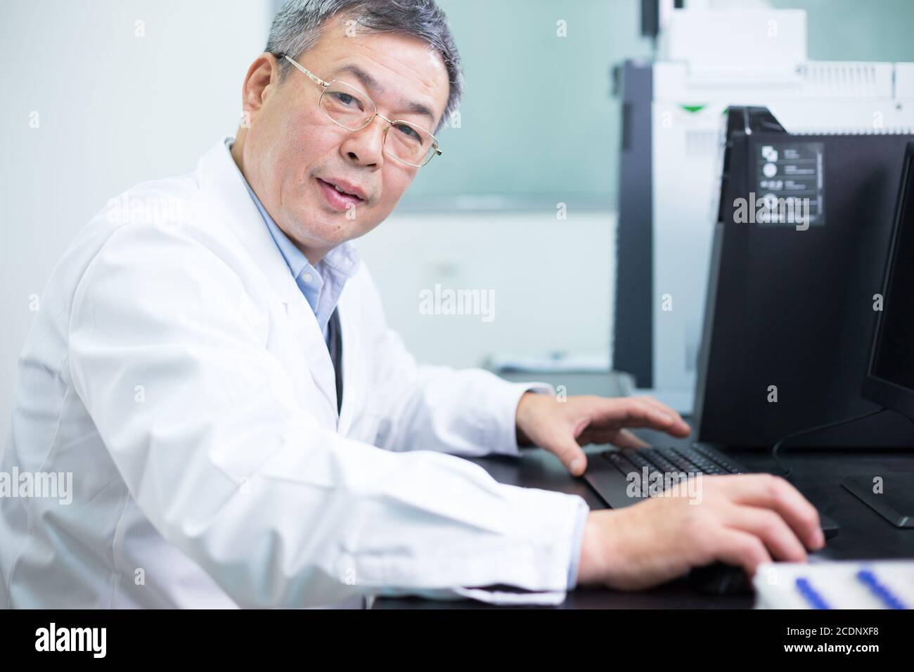 Asiatische alter Mann Analysen experimentellen Daten im Labor Stockfoto