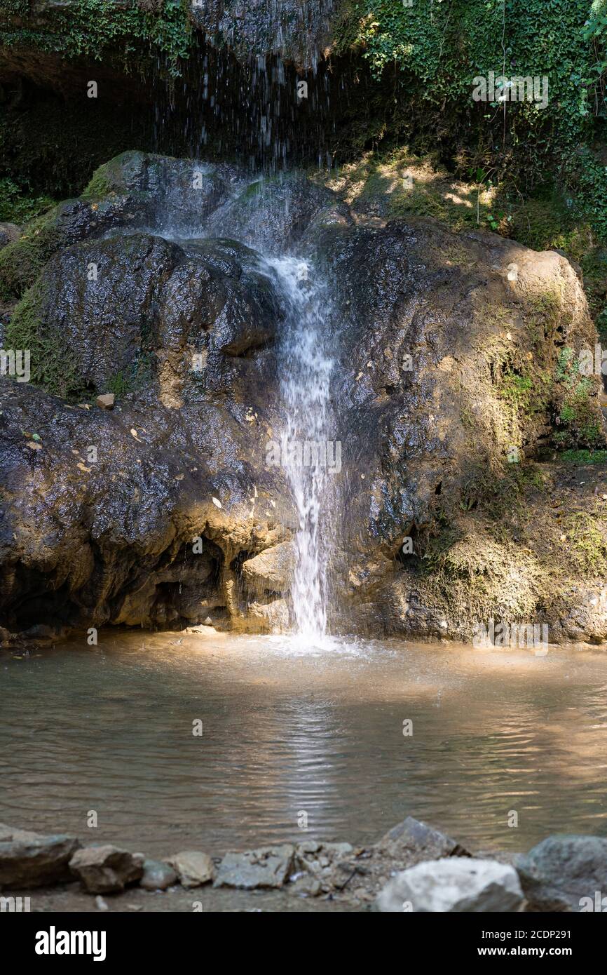 Kleiner Wasserfall mit reflektierendem See und Sonnenstrahlen im Wald. Scenie für Meditation Konzept. Größter Wasserfall des Kantons Aargau, in Lanner Bözberg, SWI Stockfoto