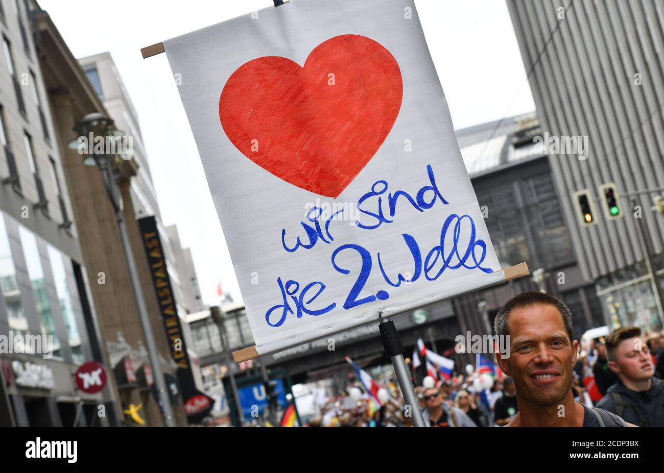 Berlin, Deutschland. August 2020. Ein Teilnehmer hält in der Friedrichstraße bei einer Demonstration gegen die Corona-Maßnahmen ein Schild "Wir sind die 2. Welle". Quelle: Paul Zinken/dpa/Alamy Live News Stockfoto