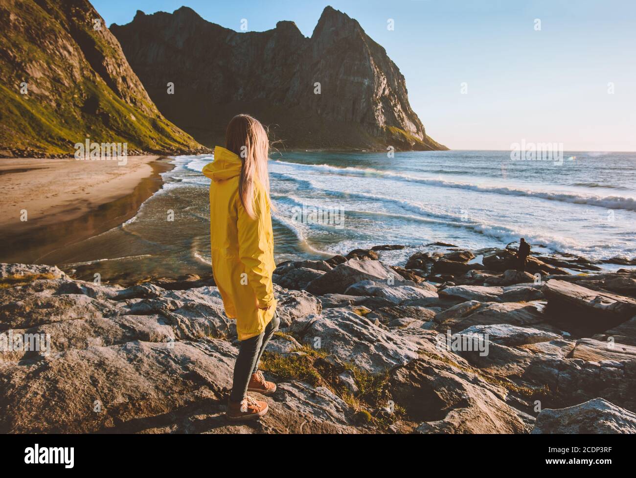 Frau in gelber Regenjacke, die alleine am Strand von Kvalvika läuft Reisen Sie in Norwegen und genießen Sie einen aktiven und gesunden Lebensstil Tourismus raus Stockfoto
