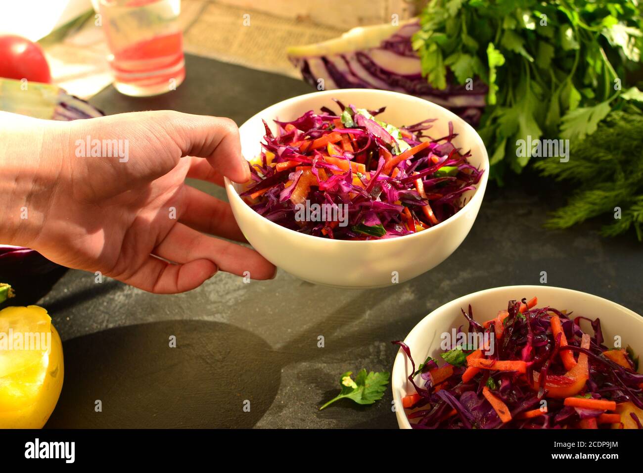 Rotkohlsalat mit Paprika und Karotten. Dunkler Hintergrund. Gesunde helle Lebensmittel. Stockfoto