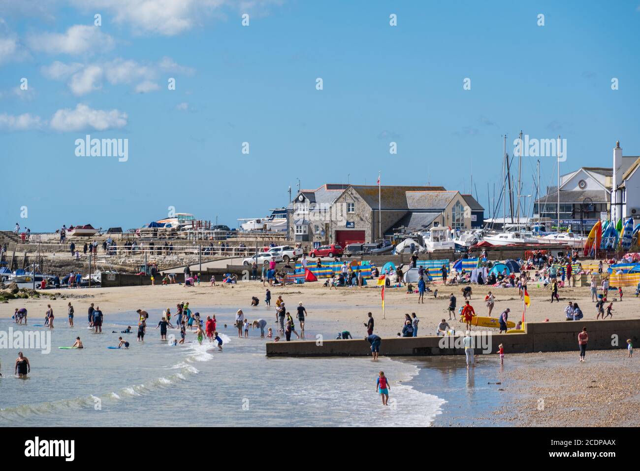 Lyme Regis, Dorset, Großbritannien. August 2020. UK Wetter: Urlauber und Familien strömen an den Strand am Badeort Lyme Regis, um den letzten Sommerurlaub an einem stürmischen Tag mit heißen Sonnenzaubern zu genießen. Kredit: Celia McMahon/Alamy Live Nachrichten Stockfoto