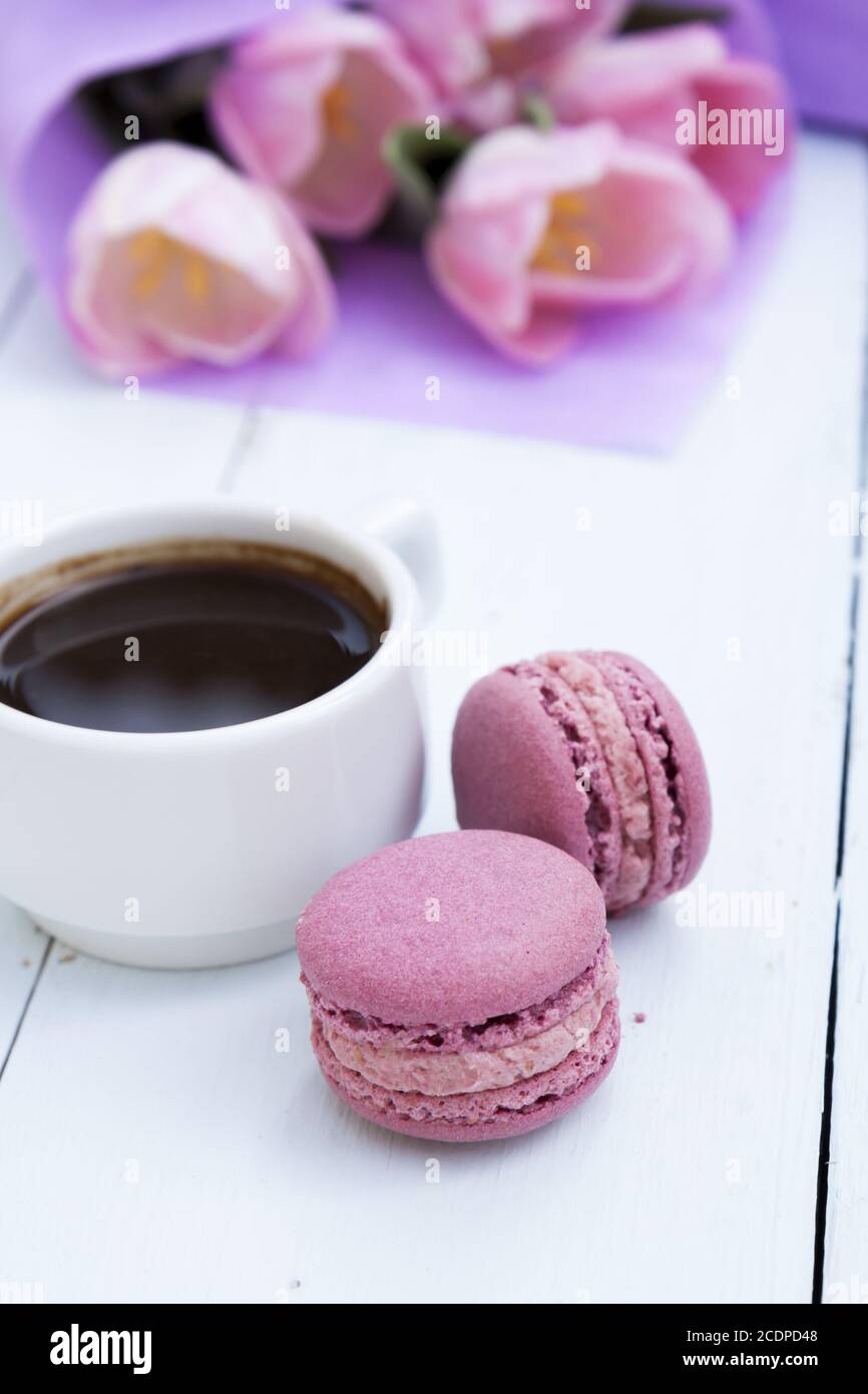 Tasse Kaffee und zwei rosa Makronen auf hölzernen Hintergrund Stockfoto